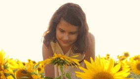 Happy portrait little girl on the field of sunflowers in summer. beautiful portrait little girl in sunflowers. slow motion video. girl teenager and sunflowers field concept agriculture lifestyle