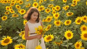 Happy little girl on the field of sunflowers in summer. lifestyle beautiful little girl in sunflowers. slow motion video. girl teenager and sunflowers field concept agriculture