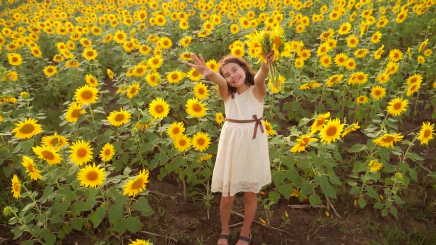 Happy little girl on the field of sunflowers in summer. beautiful little girl in sunflowers.