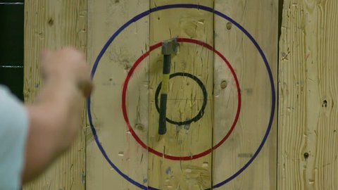 Man Throwing Axe and Hitting Wood Target in Slow Motion