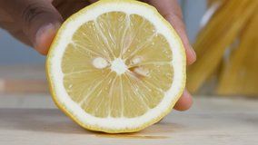 Close up shot hands of woman using kitchen knife slice cut fresh lemon on wood cutting board