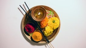 Hindu Pooja or Puja thali consisting of diya, flowers, kumkum, turmeric, rice grains arranged in a brass plate