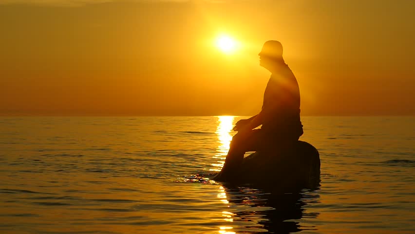 man on rock far from a shore praying silhouette at sunset Royalty-Free Stock Footage #1014837685