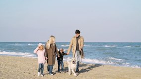 Happy lovely family walks on beach with their big dog