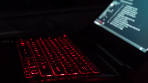 Hacker Typing Code on Laptop