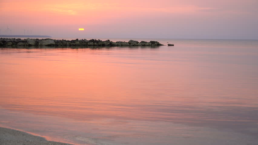 4K scenic red sunrise background sun rising. Close up video of sun rising behing sea