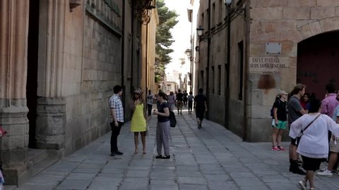 Salamanca, Spain - August 2018: Three people enter the University of Salamanca throught the entrance in the Calle Libreros.