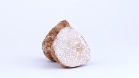 Two large white truffle mushroom halves rotating on the turntable isolated on the white background. Closeup. Macro.