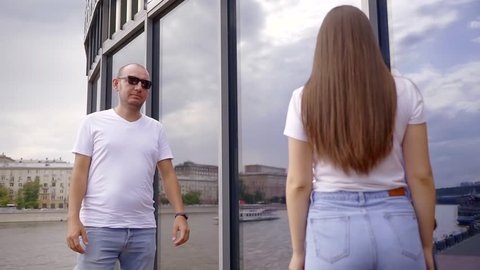 Man and woman meet near the building in the city in summer.