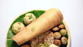 footage of South Indian food like Masala Dosa, Uttapam, Idli/idly, Wada/vada, sambar, appam, semolina halwa, upma served over banana leaf with colourful chutneys, selective focus
