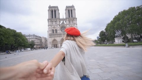 Follow me concept: Male following girlfriend holding hands in Paris POV. Follow me to Paris,  Happy Young woman leading her boyfriend in slow motion 
