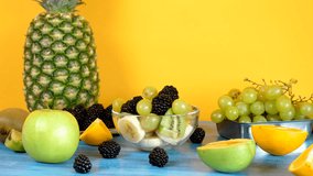 Delicious homemade fruit salad in glass bowl on yellow background. Parallax dolly footage