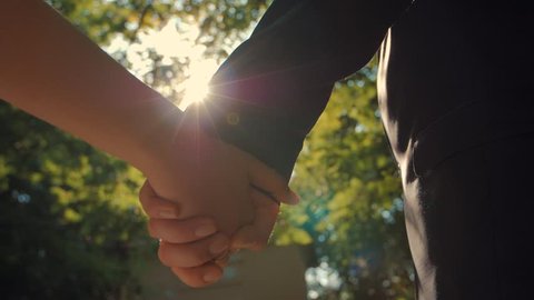 Young couple holding hands. Slow motion close up shot.