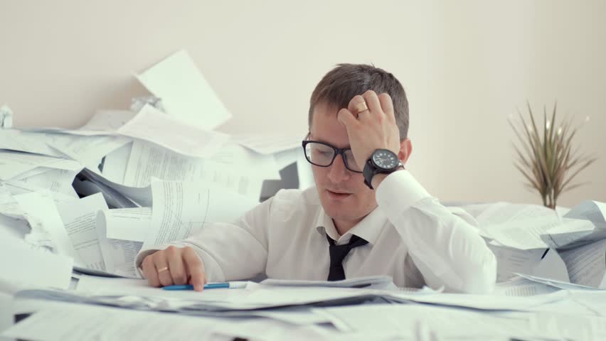 Young businessman hid behind with stack papers. a huge pile of papers scattered on the table. paper work young man with glasses. | Shutterstock HD Video #1014886012