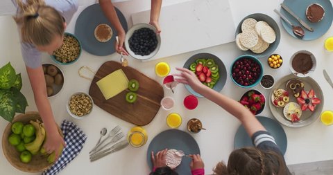 above view group of young creative multi ethnic girls making tasty homemade sweets together healthy vibrant food in kitchen time lapse rotate