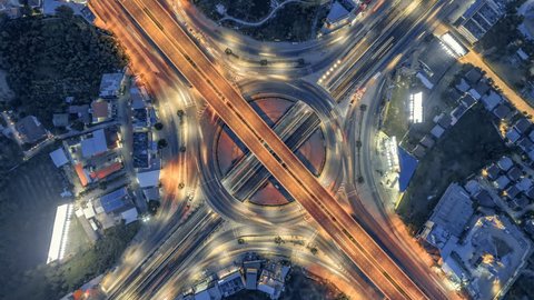 timelapse of night city traffic on 4-way stop street intersection circle roundabout in bangkok, thailand. 4K UHD horizontal aerial top view.