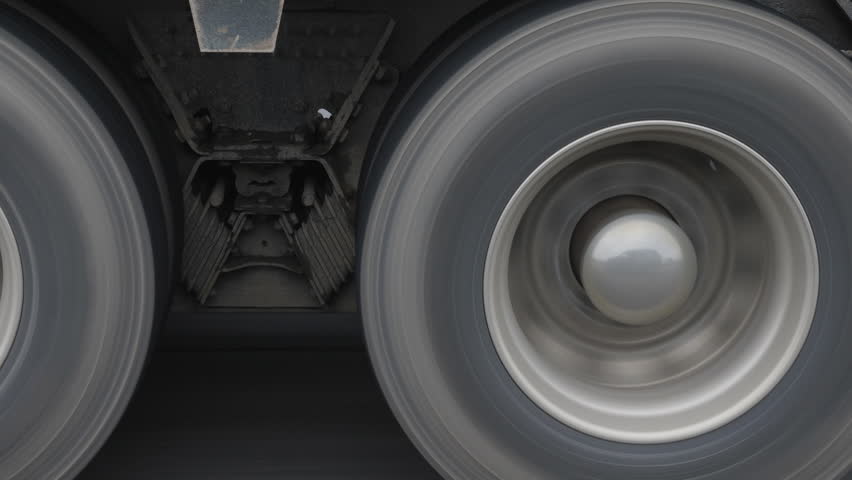 Closeup of truck wheels and tires with suspension. Passing truck on highway. Royalty-Free Stock Footage #1014906373