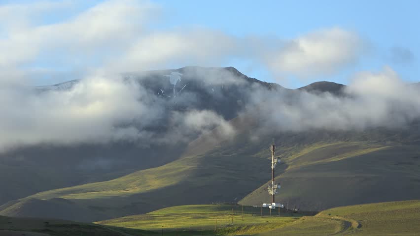 Timelaps of Kuray mountain range with repeater fnd running clouds on blue sky in evening time. Altai Mountains, Siberia Russiia