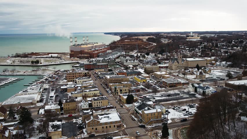 Low altitude, cinematic aerial footage of a town by the lake during winter/fall. Port Washington, WI.