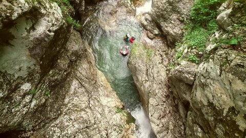 Aerial view of couple throwing in sliding rock at Soca river, Slovenia.