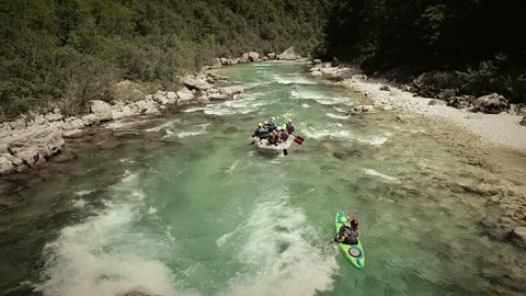 ISONZO, SLOVENIA - JUNE 11, 2018: Aerial view of a group in a rafting boat going through the rocks at Soca River, Slovenia.