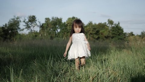 Slow motion, Little girl walking on green grass