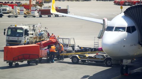 ISRAEL - CIRCA MAY 2017 - Ground crew personal load luggage on airplane ramp, Ben Gurion Airport, Israel