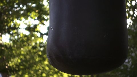 Boxer punching bag, on the outdoor. Slow motion sequence.