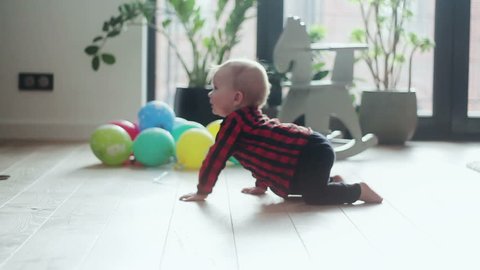 Little baby boy with crawling on the floor at home
