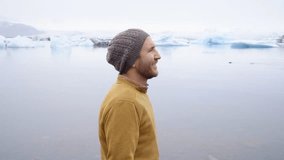 View of tourist male looking at glacier lagoon enjoying nature travel people concept in Northern Europe, shot in Springtime, icebergs on lake. 4K resolution