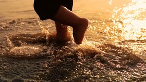 Following and undefined baby feet walking on beach at sunset with sea waves splashing his barefoot legs, SLOW MOTION - Powered by Shutterstock - Get 15% off with code: PIKWIZARD15