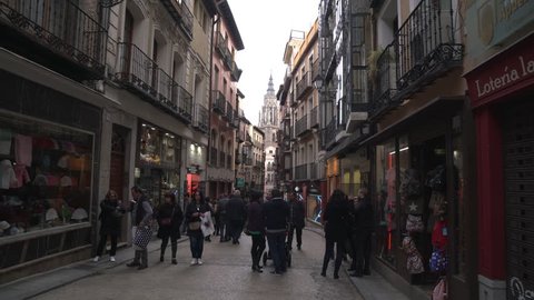 Toledo, Spain - April, 2017: People walking on a street with stores.