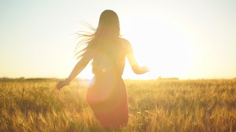 Happy Young Beautiful Woman In Yellow Dress Running On Wheat Field In Sunset