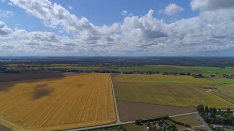 Aerial hyperlapse of approaching white clouds and shadows over a crop field. Lots of shadows at the end of clip.