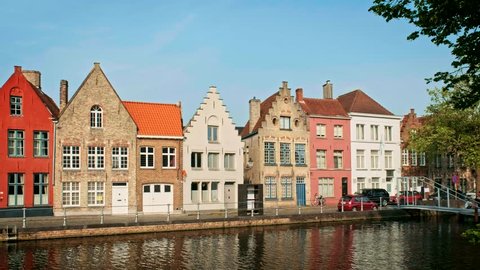 Old houses and canal in famoust tourist town of Bruges (Brugge) on sunset, Belgium. With camera pan