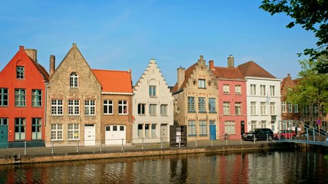 Old houses and canal in famoust touris town of Bruges (Brugge) on sunset, Belgium. With camera pan