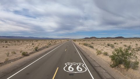 Aerial fly over of historic Route 66 pavement sign in the scenic California Mojave desert.