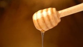 Footage organic honey dripping from wooden honey spoon background. 4k video