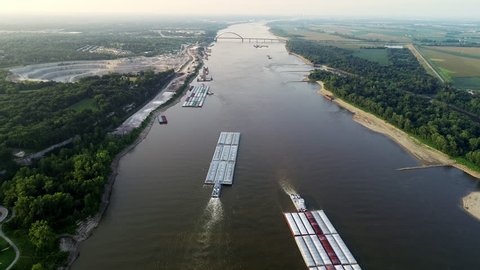 Barges passing rock quarry on the Mississippi River in 4k.