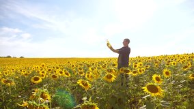 Man farmer hand hold bottle of sunflower oil the field at sunset. man shows on the production of sunflower oil in a field at sunset plastic bottle. slow motion video. man farmer agriculture plastic