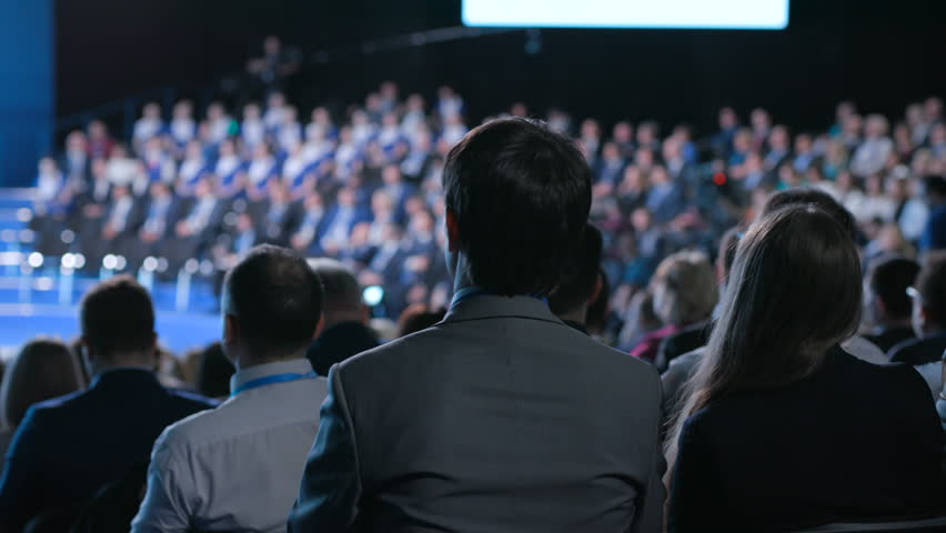 Confident official male team works at crowded forum for trading collaboration or education. Concept of briefing for economic partners or politicians indoors. Row of seats in large place for job worker Royalty-Free Stock Footage #1014974365