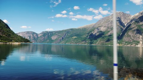 A beautiful fjord in Norway, the mountains are reflected in the water. View from the window of the traveling bus