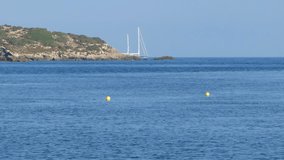 Beautiful video of a sailboat appearing behind an island of Ibiza