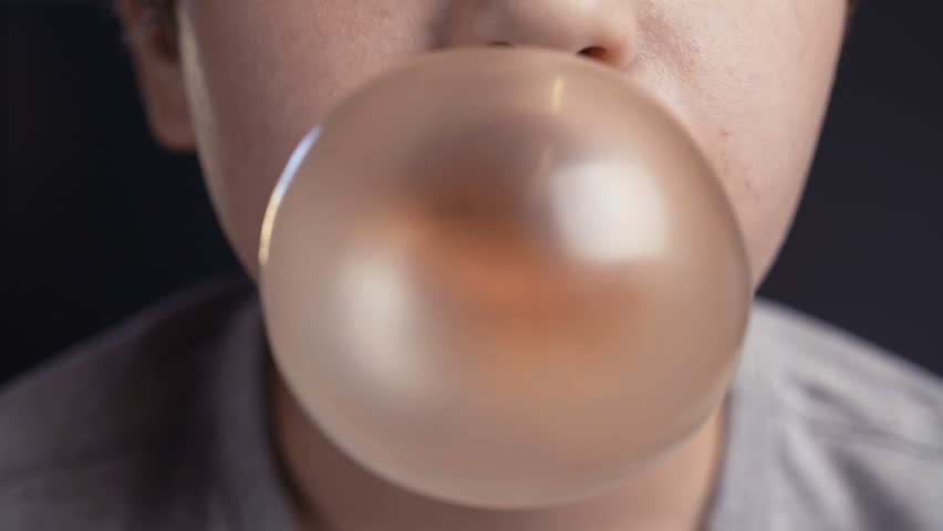 Footage boy make bubble with chew on dark background. 4k video Royalty-Free Stock Footage #1014988600
