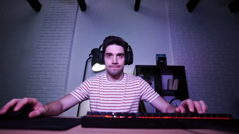 Concentrated angry brunette man playing video game and sitting in front of monitor
