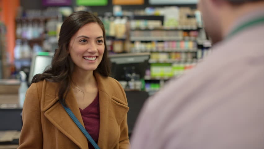 Handheld shot of female customer talking to worker at checkout counter in store Royalty-Free Stock Footage #1014999673