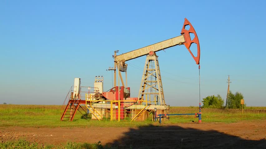 The oil pump, industrial equipment. Oil rocking at sunset in Russia, Republic of Bashkortostan