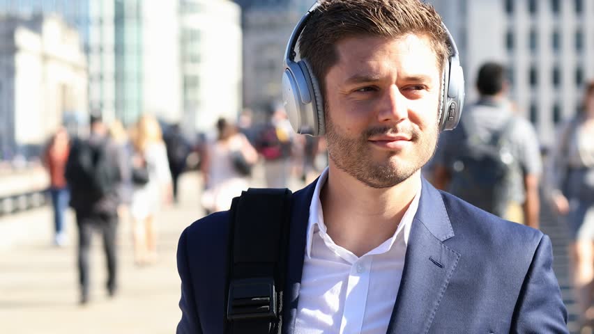 Businessman Wearing Wireless Headphones Walking To Work In Slow Motion