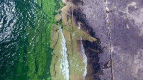 4K Drone Aerial Shot of Manitoulin Island Shore in Ontario, Canada. Lake Huron Green Teal Clean Waves. Birds Eye View on Splashing Waves
