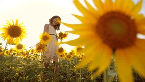 Cute child girl in yellow garden of sunflowers sunlight in summer. beautiful sunset little girl in sunflowers. slow motion video. girl teenager and sunflowers field lifestyle concept agriculture